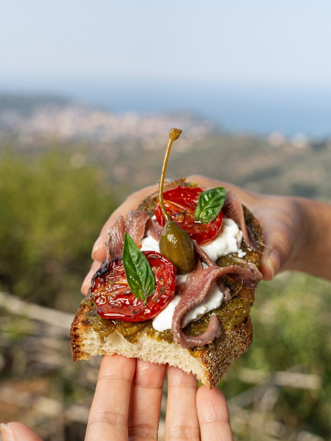 La bruschetta in mano con il mare di Agropoli sullo sfondo