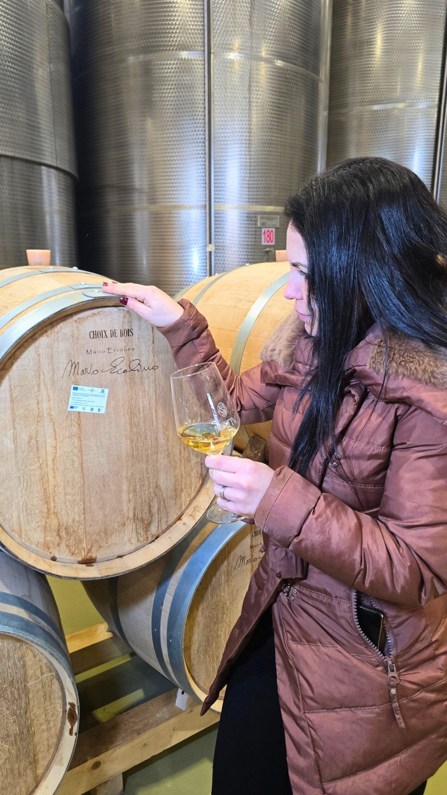 Francesca assaggia un bianco tra le botti